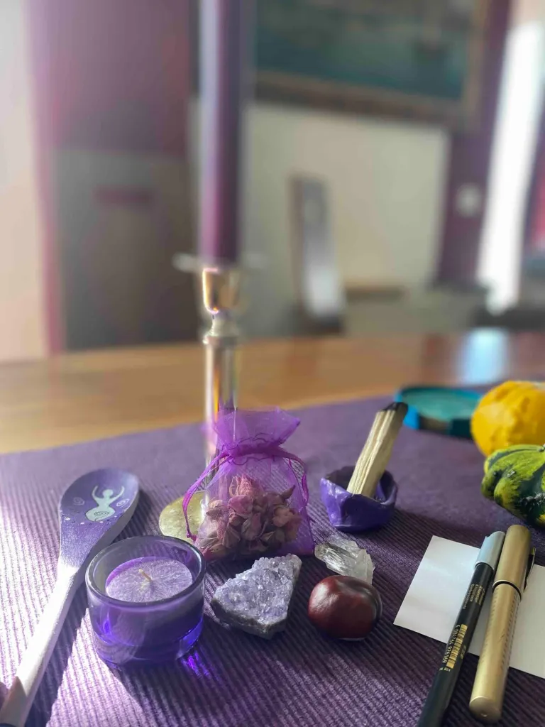 Altar mit violetten Kerzen, Amethyst und Kristallen für das Mut-Ritual