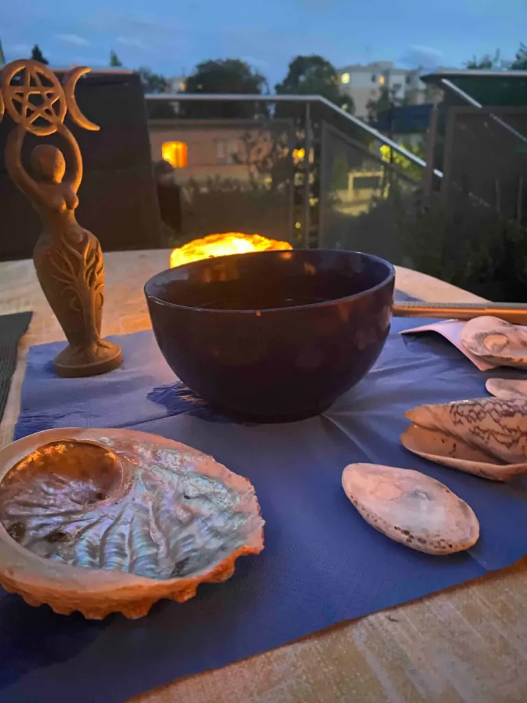 Vollmondaltar mit Wasserschale, Muscheln und Göttinnenfigur am Abend