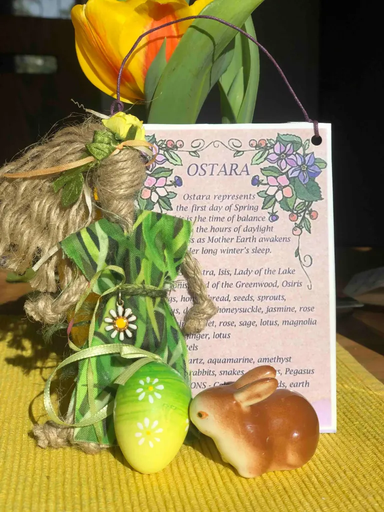 Ostara-Altar mit Strohfigur der Göttin Ostara, Tulpen, bemaltem Ei und Hase