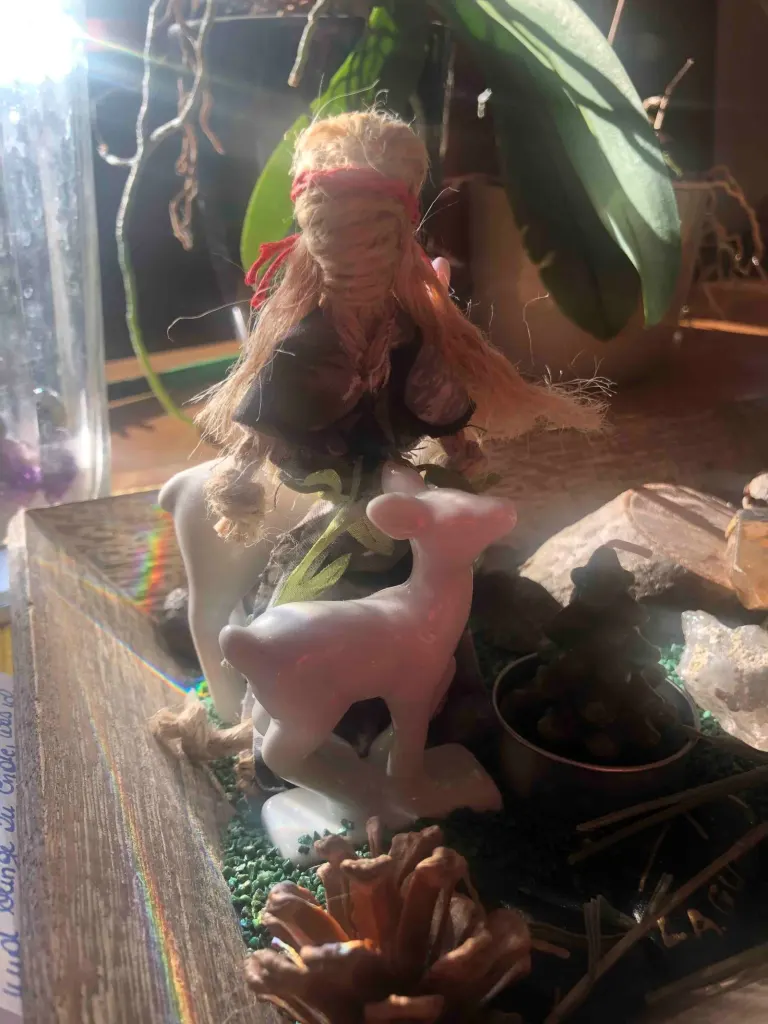 Altar mit Brigid-Figur, Kerzen und Tannenzapfen