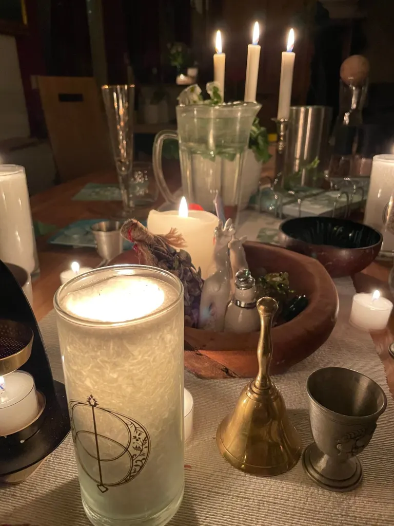 Imbolc-Altar mit vielen Kerzen, Kelch und Glocke