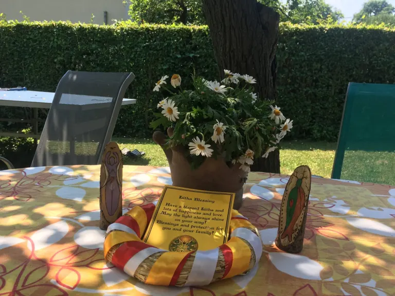 Gedeckter Gartentisch mit Blumen und Kerzen zum Litha-Fest